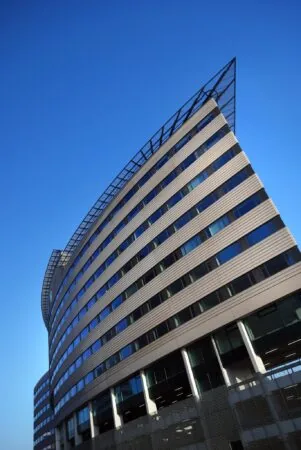 Modern kantoorgebouw aan de Rivium Boulevard met een opvallend gebogen gevel en strakke lijnen tegen een heldere blauwe lucht.